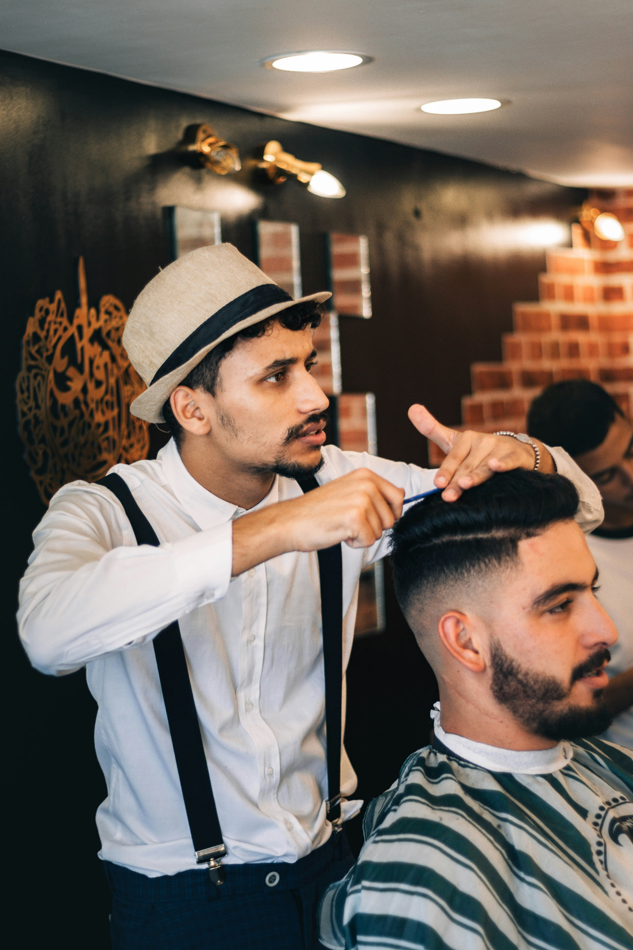 Barber combing and styling a client's hair at The Gentry