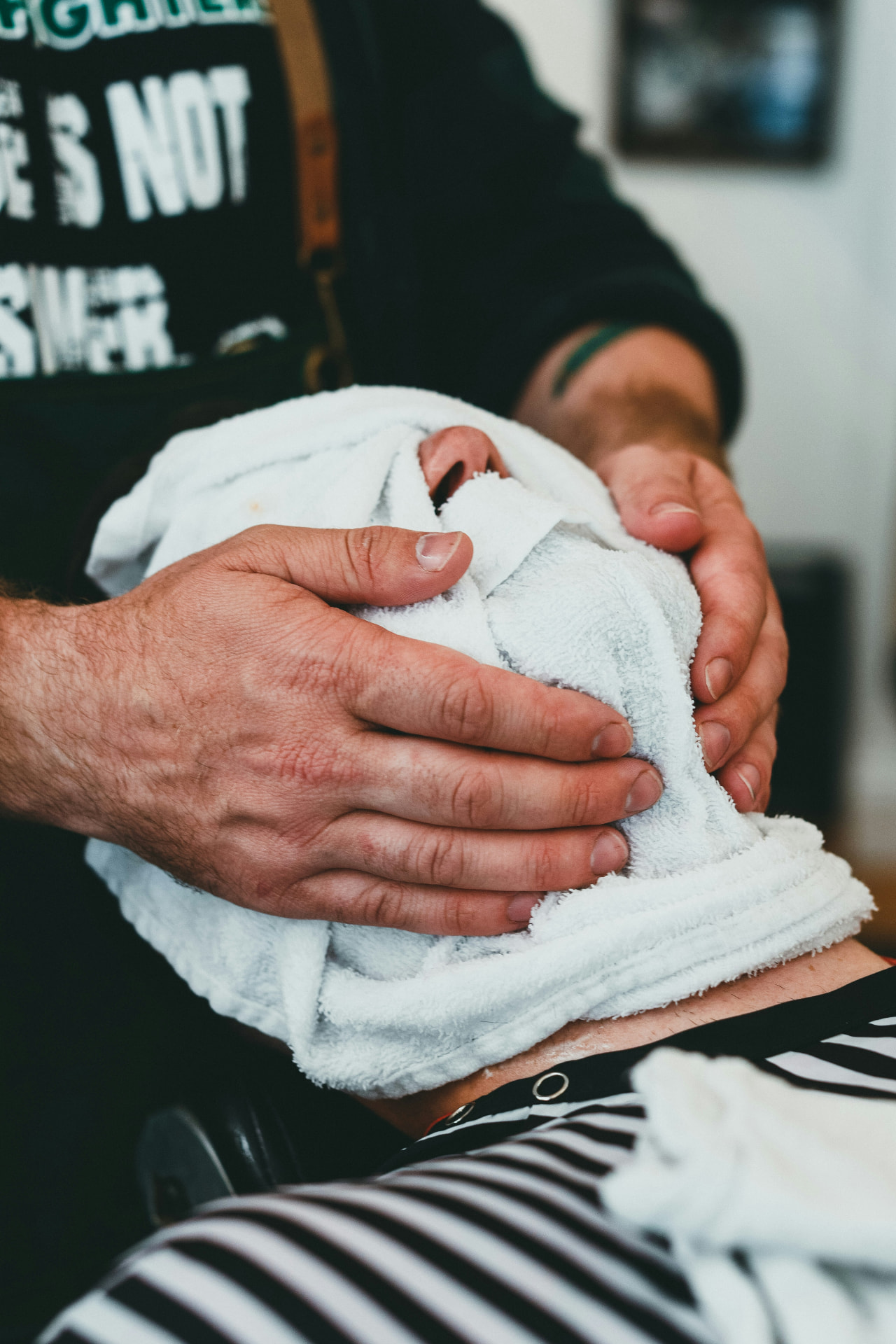 Barber applying a hot towel during The Gentry Experience service